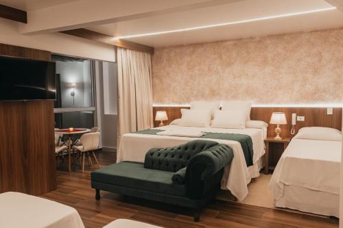 瓜拉图巴Hotel Cabana Suiça的酒店客房,设有两张床和一张沙发