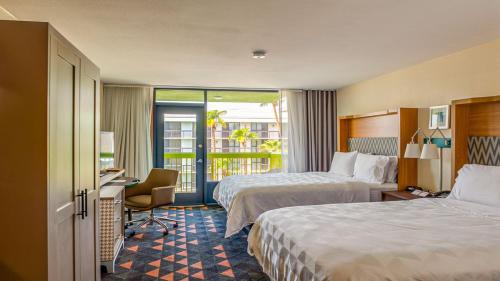 梅萨Holiday Inn & Suites Phoenix-Mesa-Chandler, an IHG Hotel的酒店客房设有两张床和一个阳台。
