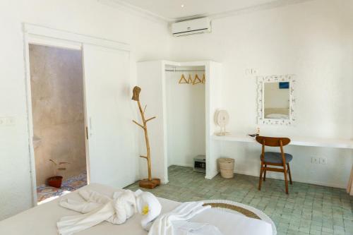 金巴兰Surga Tropical Suites的白色的客房配有一张床和一张书桌