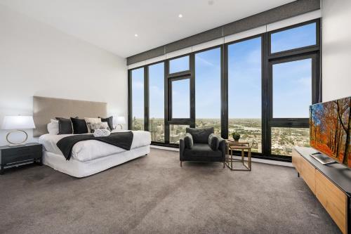 墨尔本Melbourne City Apartments Panoramic Skyview Penthouse的一间卧室设有一张床、一台电视和窗户。