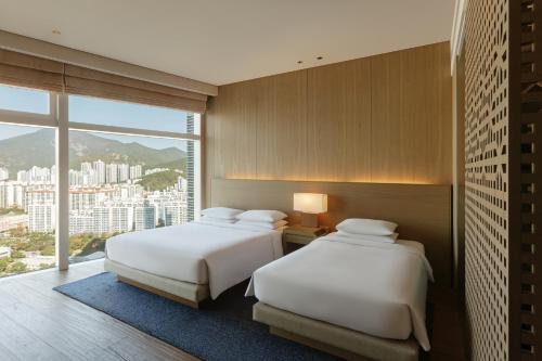 釜山釜山柏悦酒店的带大窗户的客房内的两张床