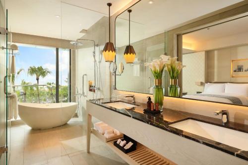 三宝垄Padma Hotel Semarang的带浴缸的浴室和卧室