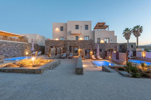 纳乌萨Paros Comfy Suites的一座带两个游泳池和大楼的度假村