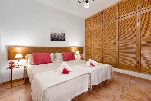 La GuanchaCasa Teresa的一间卧室配有两张带红色枕头的床。