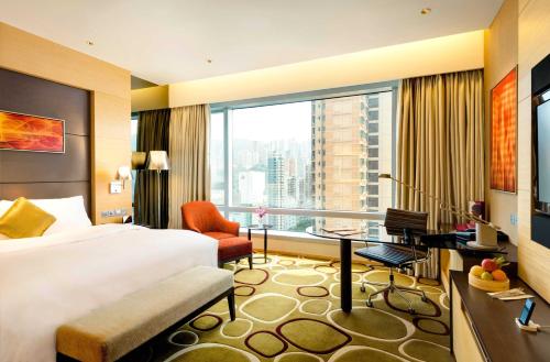 香港香港铜锣湾皇冠假日酒店的配有一张床、一张书桌和一扇窗户的酒店客房