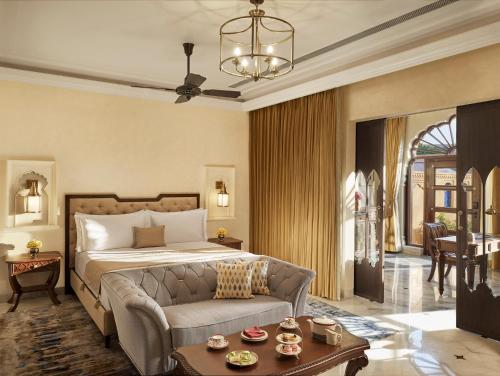 斋浦尔Sawai Man Mahal的一间卧室配有一张床、一张沙发和一张桌子