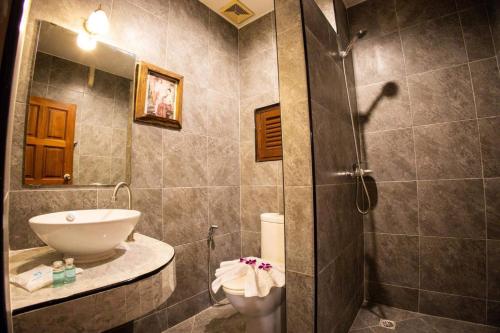 芭东海滩Rico's Patong Hotel的带淋浴、盥洗盆和卫生间的浴室