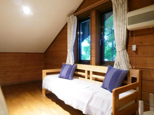 山中湖村Forest Villa Yamanakako的一间卧室设有一张床和一个窗口