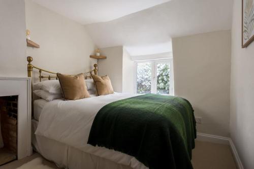 AdlestropCharming 17th Century Cotswold Cottage的一间卧室配有一张带绿毯的床