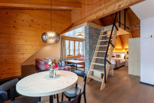 安德马特Sonne Andermatt Swiss Quality Hotel的客房设有楼梯和桌椅