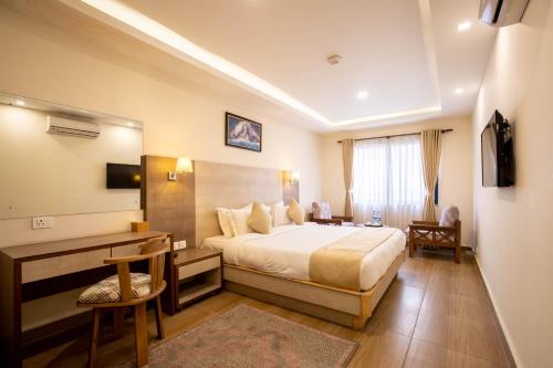 迦瓦拉科尔Sarovar Residency Serviced Apartment Hotel的配有一张床和一张书桌的酒店客房