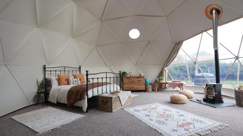 牛津Luxury Dome with Private Wood-Fired Hot Tub的帐篷内一间卧室,配有一张床