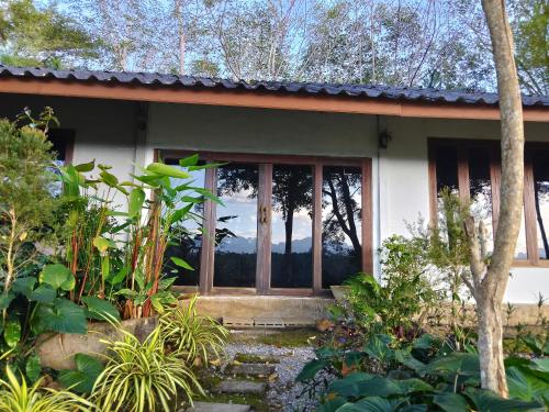 Ban Pha Saeng Langภูริรักษ์ โฮมสเตย์的花园中带玻璃门的房子