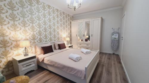 克卢日-纳波卡5* luxury near Avram Iancu sq New. Private parking的卧室配有一张白色大床和吊灯。