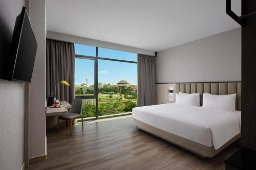 巴淡岛中心Hotel Santika Batam的卧室设有白色的床和大窗户