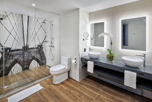 纽约NH Collection New York Madison Avenue的浴室配有卫生间、两个盥洗盆和淋浴。