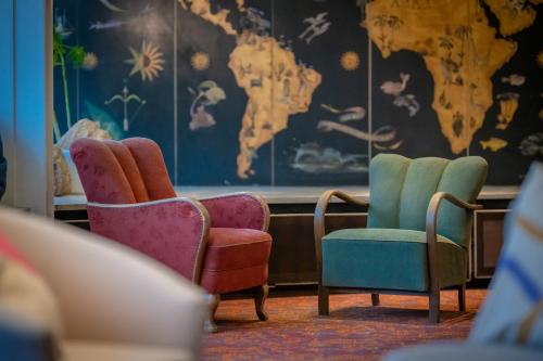 卡塞尔Hessenland Hotel Kassel Innenstadt by Stay Awesome的一间房间,配有两把椅子和一张世界地图
