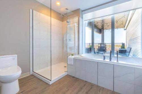维多利亚维尔维多利亚维尔品质酒店套房的白色的浴室设有浴缸和卫生间。