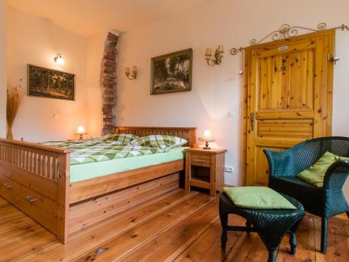 波茨坦Ferienwohnungen Romantika的一间卧室配有一张床和一把椅子