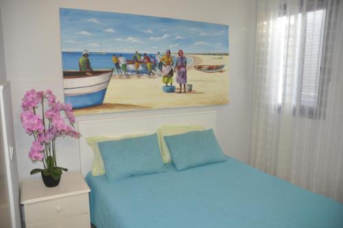 埃斯帕戈斯Apartamento Moradias Djadsal próximo à Praia de Santa Maria的卧室配有一张蓝色的床,墙上挂着一幅画