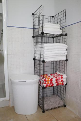 埃斯帕戈斯Apartamento Moradias Djadsal próximo à Praia de Santa Maria的浴室内带毛巾和水桶的毛巾架