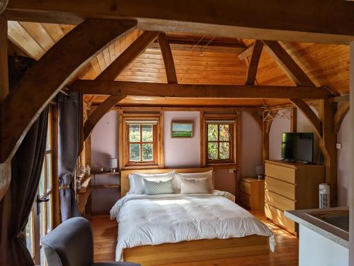 布罗肯赫斯特Cabin in the Forest的一间带一张床的卧室,位于带木制天花板的房间内