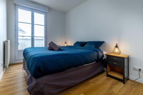 塞里斯Appart'Hôtel Gibraltar Disneyland Paris的一间卧室配有一张带蓝色毯子的床和窗户。