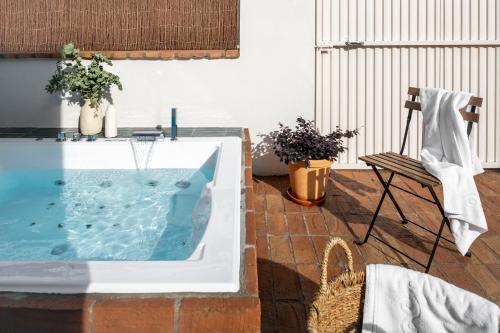 塞维利亚Magno Apartments Robles with Bath Tub and Private Parking的庭院内的热水浴池和椅子