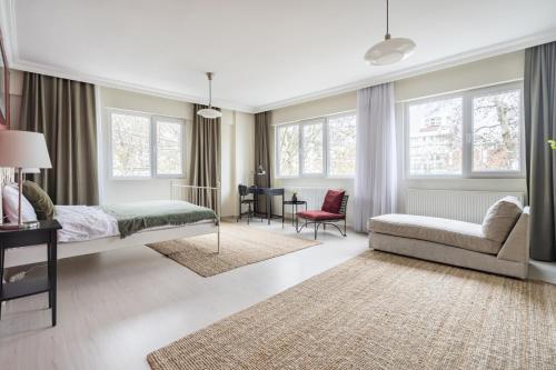 伊斯坦布尔Modern Flat with Balcony on Bagdat Street的一间卧室配有一张床、一张沙发和窗户。