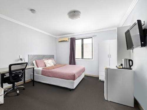 悉尼Sunny Rooms Mascot的一间卧室配有一张床、一张书桌和一台电视。