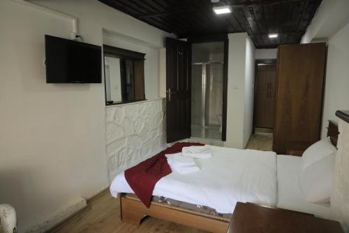 阿马西亚SALİH BEY KONAĞI的卧室配有一张床铺,墙上配有电视
