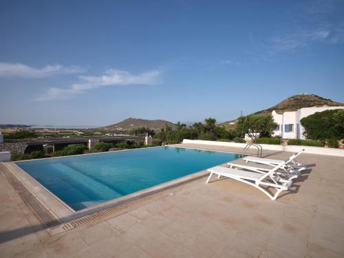 帕罗斯岛Nola Traditional Villa with pool and amazing sea views, Paros的一个带2把躺椅的游泳池和一个游泳池