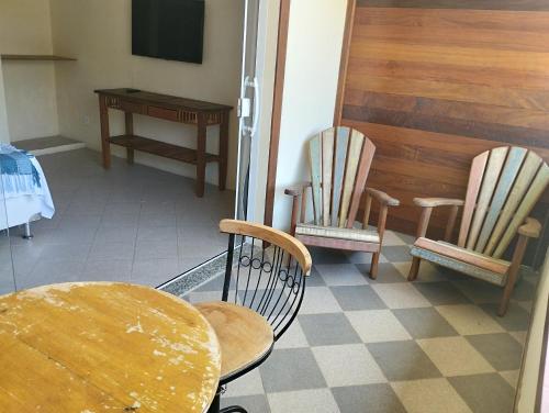 布希奥斯Andorinhas Suites的一间设有两把椅子、一张桌子和一台电视的房间