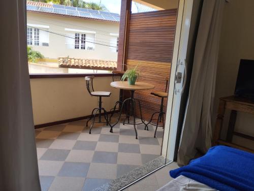 布希奥斯Andorinhas Suites的客房设有带桌椅的阳台。
