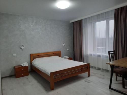 米尔哥罗德PerfectHotel的一间卧室配有一张床、一张桌子和一个窗户。