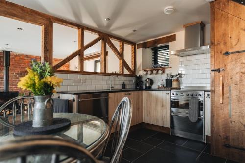 布德Swallows Nest的厨房配有玻璃桌和炉灶。