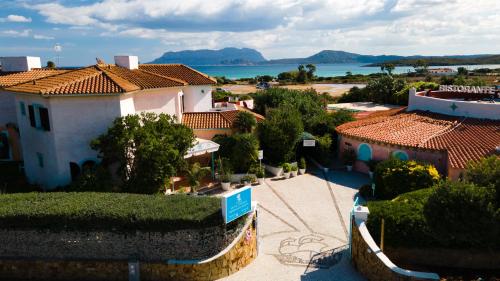 奥尔比亚斯特法尼亚海滩边酒店的享有小镇的空中景致,设有房屋和大海