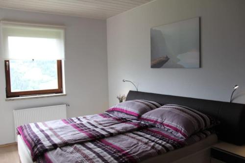 ZödlGemütliches Bergappartement mit Seeblick的一间卧室配有一张带两个枕头的床
