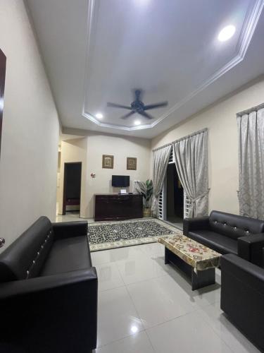 亚娄TDH Homestay Arau FREE Wifi的客厅配有黑色沙发和吊扇