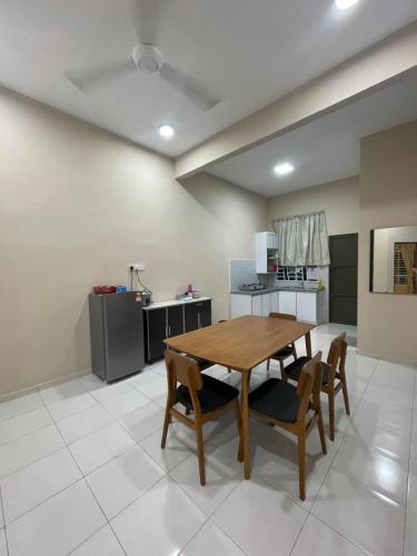 亚娄TDH Homestay Arau FREE Wifi的厨房以及带木桌和椅子的用餐室。