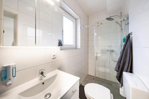 林特尔恩Modernisiertes Altbau 3-Zi Apartment的白色的浴室设有水槽和淋浴。