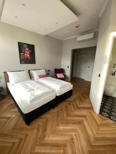 维也纳Boutique Hotel Kolbeck的一间卧室配有一张床,铺有木地板