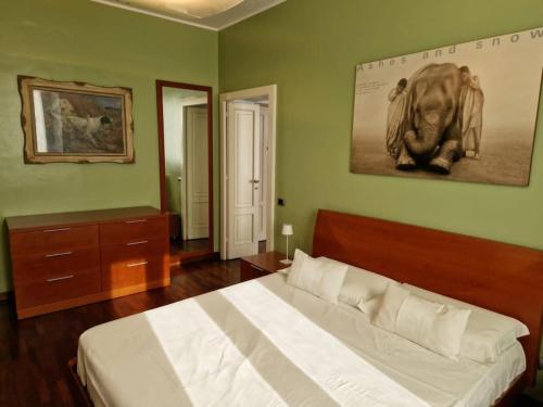 米兰Cozy flat mins walk to Navigli and metro Porta Genova的卧室配有一张床,墙上挂着一幅大象的照片