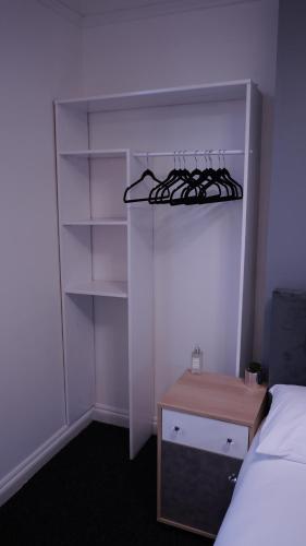 伯明翰Reach Guest House的一间卧室配有一张床和一个带架子的衣柜