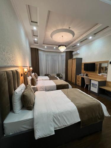 杜尚别Hotel Sharq的酒店客房设有三张床和一张书桌