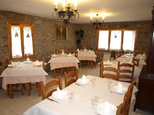Sieste卡萨皮克罗乡村民宿的餐厅设有白色的桌椅和窗户。