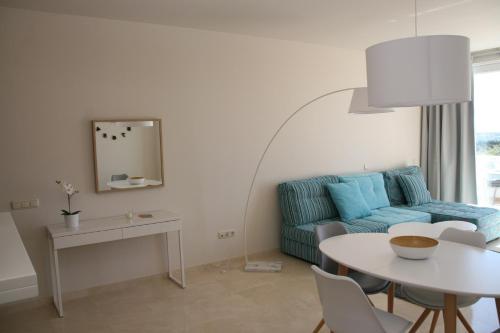Estepona2152-Modern apt with private beach的客厅配有蓝色的沙发和桌子