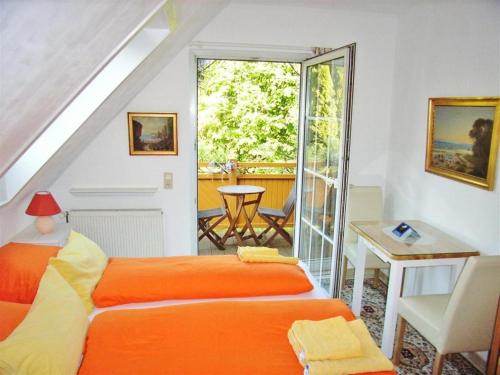 巴特多布兰Ostsee Hotel-Pension An der Lindenallee的一间卧室配有橙色的床和桌子