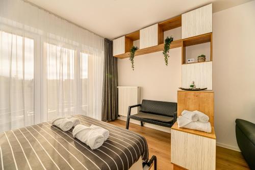 布拉索夫Luxury Landing Apartments Complex Qualis Brasov的一间卧室配有一张床和一把椅子