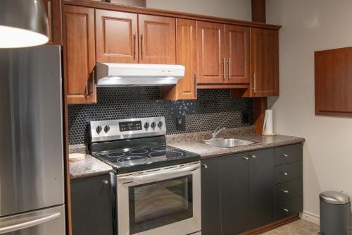 拉拜Appartements Victoria的厨房配有木制橱柜和炉灶烤箱。